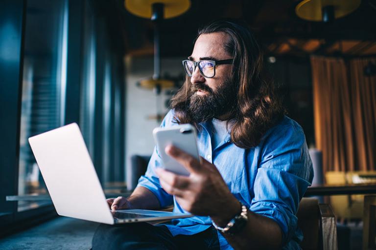 man using catalog on laptop