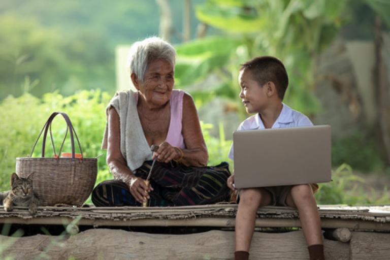 grandma and grandson outside with devices